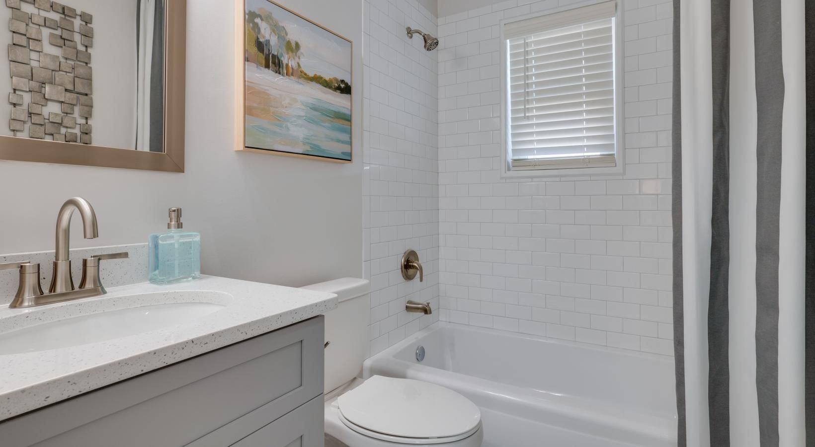 Spacious bathrooms with everything you need ample lighting in bathroom with shower/tub combo