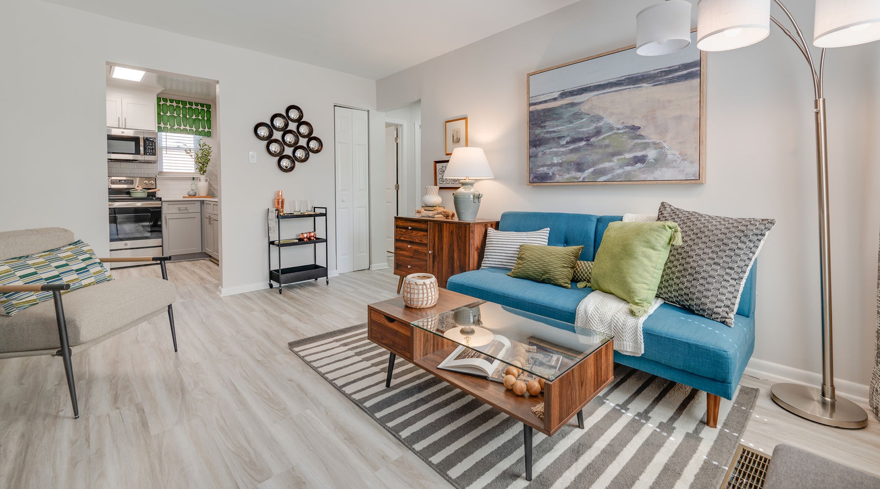 The Art of Living furnished living room adjacent to kitchen