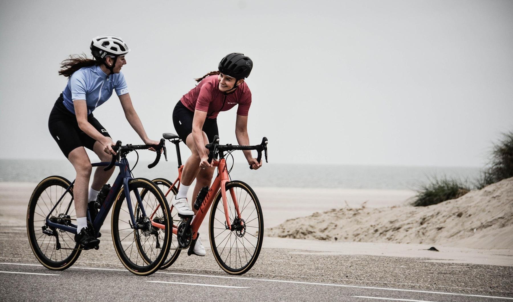 A beautiful community at the heart of all your passions women bicycling on the road along a beach